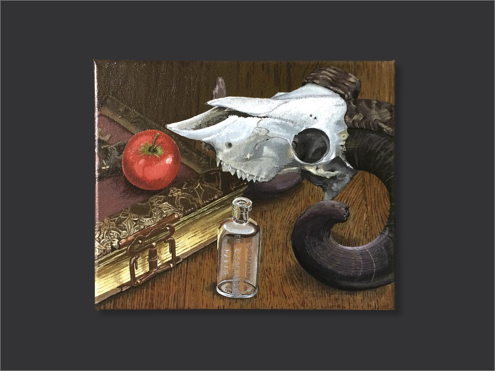 compositie antiek boek met slot, hierop een rode appel, met een klein glazen flesje en schedel van ram
